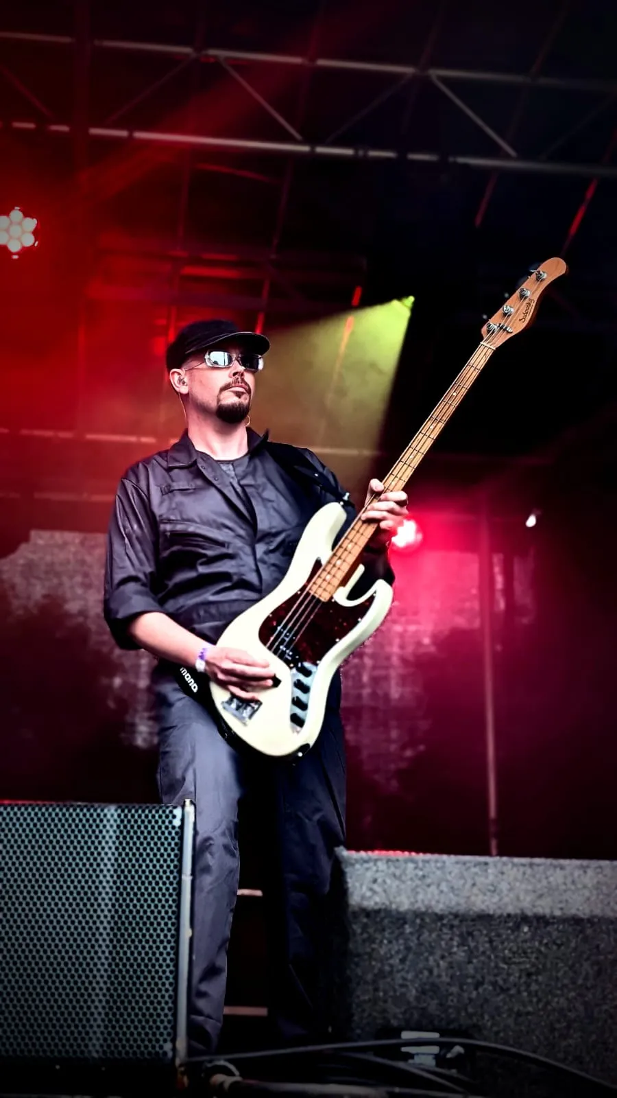 U2.V2 bassist on stage under red lights at the Ultimate Festival, Dumfries