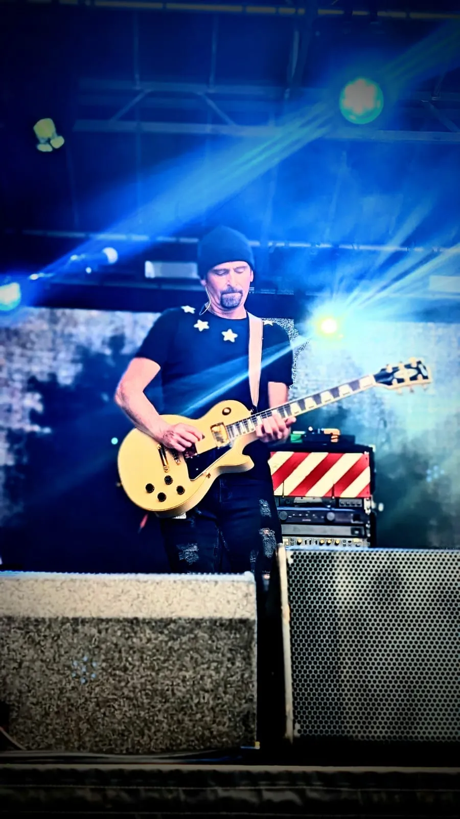 U2.V2 guitarist playing a cream Les Paul under blue stage lights at the Ultimate Festival, Dumfries